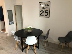 ein schwarzer Esstisch mit Stühlen und ein Schild in der Unterkunft Appartement à 15min de la mer in Montblanc