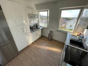 a kitchen with white cabinets and a large window at Nita in Frickenhausen