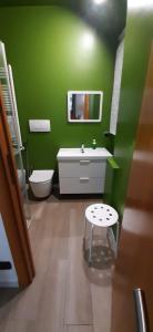 un bagno verde con lavandino e specchio di Gardenia free parking a Bari