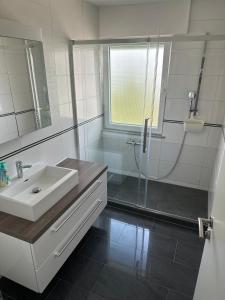 a white bathroom with a sink and a shower at Nita in Frickenhausen