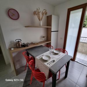 a kitchen with a table with red chairs and a table and a table at Ca' Massima, il cuore a Monza in Lissone
