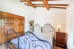 a bedroom with a metal bed and a wooden cabinet at Semidetached Villa Shared Pool - Happy Rentals in Colle