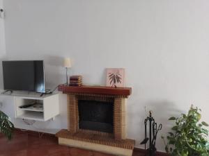 sala de estar con chimenea y TV en Preciosa casa de pueblo “La fontita 5”, en Villablanca