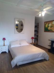 1 dormitorio con cama blanca y espejo en La Maison Bleue, en Brantôme