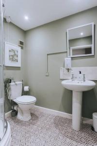 a bathroom with a toilet and a sink at 3 Bed Boutique Holiday Home in Town Centre in Tavistock