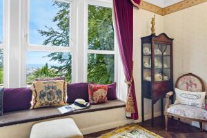 a living room with a purple couch and a window at The Round House - Panoramic views of Devon's Coast and Country in Ilfracombe