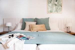 1 cama con edredón y almohadas verdes en Pinomar - Emar Hotels, en Es Caló