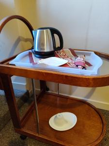 a tea kettle on a table with a plate on it at Pokój jednoosobowy z prywatną łazienką - Piotrkowska 262-264 pok 302 in Łódź