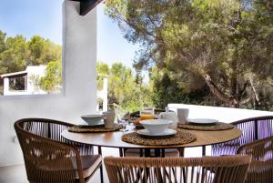 una mesa con dos sillas y una mesa con comida. en Pinomar - Emar Hotels, en Es Caló