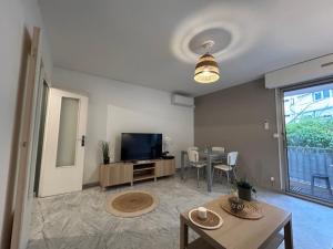 a living room with a television and a table at Appartement Cosy Montpellier in Montpellier
