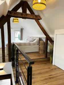 een slaapkamer met een bed en houten vloeren en balken bij Le Duplex in Auxerre