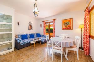 ein Wohnzimmer mit einem Tisch und einem Sofa in der Unterkunft Casa Caracola in Pollença