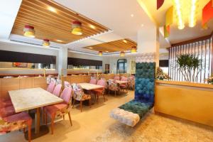 un restaurante con mesas y sillas y un bar en THE GRAND AMBASSADOR HOTEL, en Kottayam