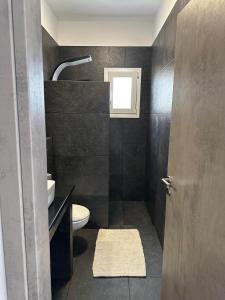a bathroom with a toilet and a sink and a window at Serenity - Brand new apartment in Ermioni Village in Ermioni