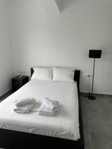 a bedroom with a white bed with towels on it at Serenity - Brand new apartment in Ermioni Village in Ermioni