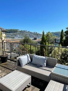 a patio with a couch and a table on a balcony at Elim in Dartmouth with stunning River Dart view in Dartmouth