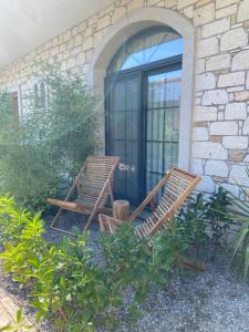 two wooden chairs sitting outside of a building at Dmira Alacati in Alaçatı