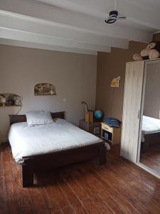 1 dormitorio con cama y espejo. en Chante Ruisseau - Petit Havre de paix Breton, en Plouguenast Langast