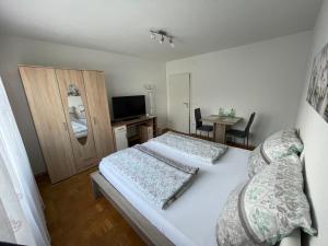 a small bedroom with two beds and a television at Nita in Frickenhausen