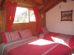 1 dormitorio con 2 camas y ventana. en Cabañas Valle Encantado Meliquina en Villa Meliquina