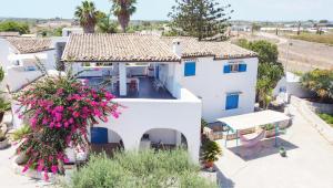 an aerial view of a white house with pink flowers at Villa Le Charme Marin - Noto, Marzamemi, San Lorenzo in San Lorenzo