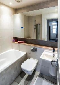 een badkamer met een bad, een toilet en een wastafel bij Superior 5* Kensington, London Flat + Free Wi-Fi in Londen