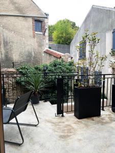 een patio met een zwart hek en een stoel en planten bij Le Duplex in Auxerre
