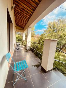 a porch with a blue chair and a table at Gite CATHARE en OCCITANIE in Espéraza