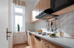 eine Küche mit einer Theke, einem Waschbecken und einem Fenster in der Unterkunft Villa Rosenhof in Norderney