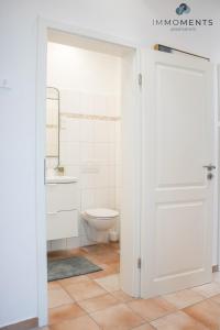 uma casa de banho com WC e uma porta branca em Stilvolles Apartment im Zentrum em Magdeburg