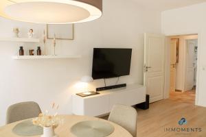 uma sala de estar com uma televisão e uma mesa com cadeiras em Stilvolles Apartment im Zentrum em Magdeburg