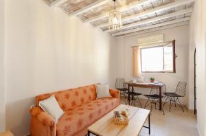 a living room with an orange couch and a table at Evaxenia's House Old Town Rhodes in Rhodes Town