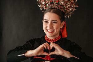 a woman wearing a crown is making a heart with her hands at Hotel Tradizio in Mittelberg