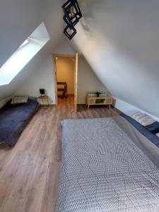 a attic bedroom with a bed and a window at Apartament Graal Roztocza in Rebizanty
