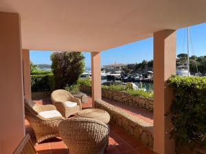 a balcony with chairs and a view of a marina at Sardegna Beach Cala Reale in Marinella