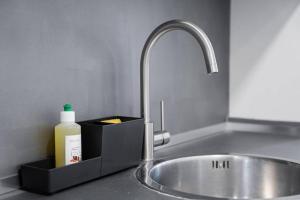 a sink with a bottle of soap next to a sink at GuestReady - A prime stay near the beach in Matosinhos