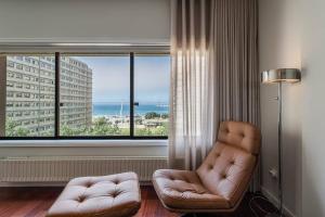un soggiorno con sedia e una grande finestra di GuestReady - A prime stay near the beach a Matosinhos