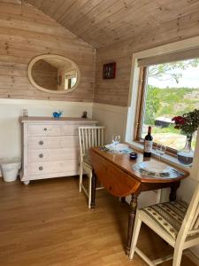 a dining room with a table and a window at Sea view chalet in Hjälteby