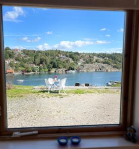 a view of a table and chairs from a window at Sea view chalet in Hjälteby