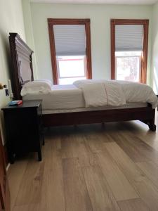 a bedroom with a large bed and two windows at Malden rooms in Malden