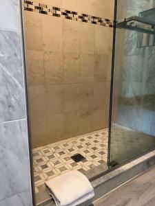 a shower with a glass door and a towel at Malden rooms in Malden