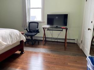 a bedroom with a bed and a desk with a television at Malden rooms in Malden