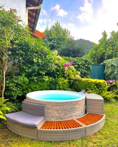 a hot tub sitting in a yard with avisor at Agradable casa con jacuzzi climatizado exterior en pleno Urdaibai in Busturia