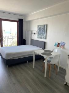 Schlafzimmer mit einem Bett und einem Tisch sowie einem Tisch und Stühlen in der Unterkunft Studio Kristof 705 in Middelkerke