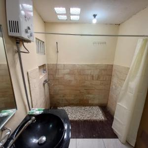 W łazience znajduje się czarna umywalka i prysznic. w obiekcie Agora Home w mieście Wonosobo