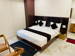 a bedroom with a large bed with a wooden headboard at Hotel Fusion in Kurukshetra