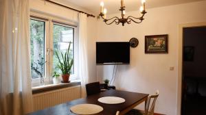 uma sala de jantar com uma mesa e uma televisão de ecrã plano em Harbart em Soltau