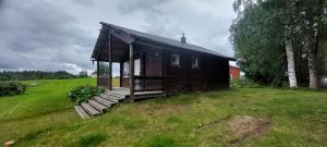 een kleine hut op een heuvel met een grasveld bij Lönås in Håptjärnliden