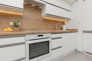 a kitchen with white cabinets and a sink at Cozy Apartment with Parking Bakalarska by Renters in Warsaw