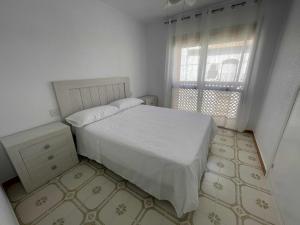 1 dormitorio con cama blanca y ventana en Calabardina Playa con Wifi Ideal para Buceadores, en Águilas